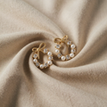 Goldfarbene Ohrringe mit Zirkonia und Perlenoptik-Schleife