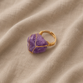 Goldfarbener Ring mit umschlungenem Amethystkristall